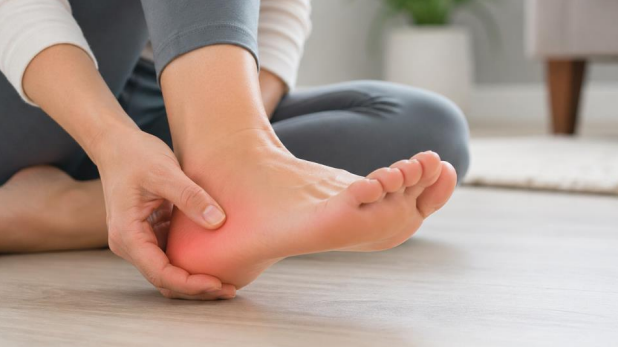 Burning heel pain shown with person holding heel and subtle redness indicating discomfort