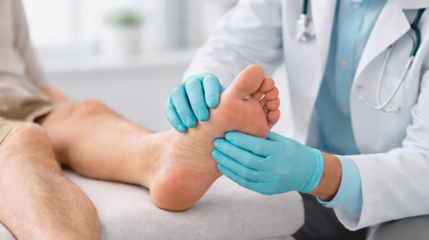 podiatrist checking foot during diabetic foot treatment consultation